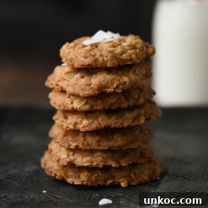 Close-up of coconut oatmeal cookies stacked with milk in the background.