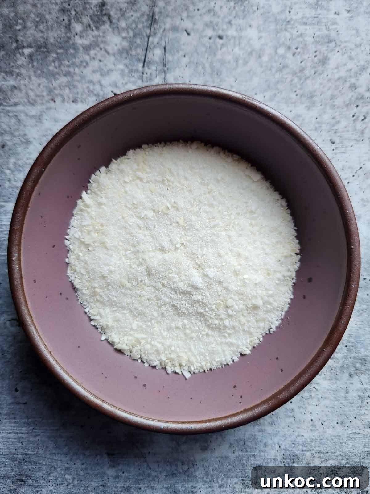 Coconut sugar in a purple bowl.