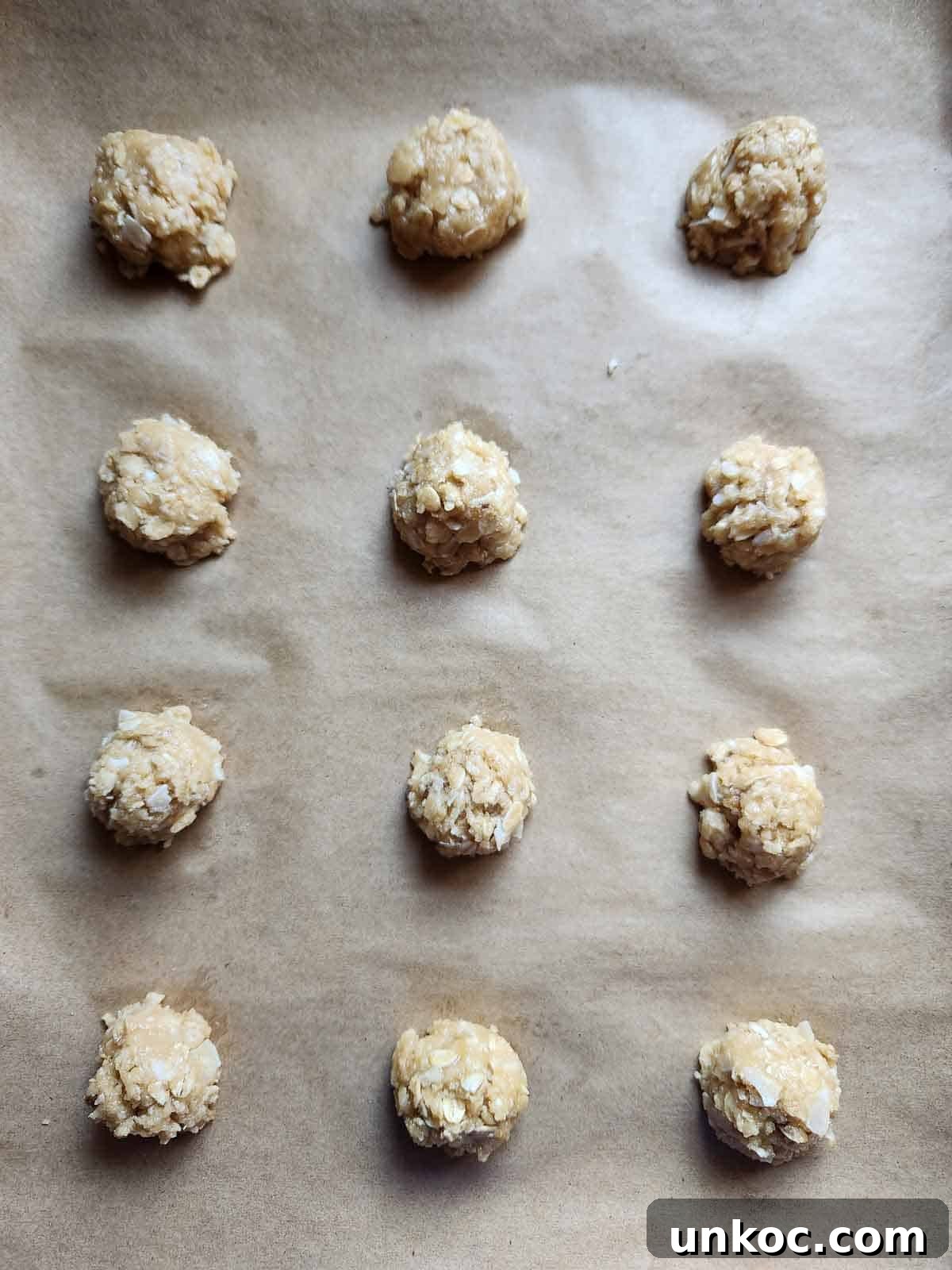 Cookie batter dropped on a parchment lined baking sheet.