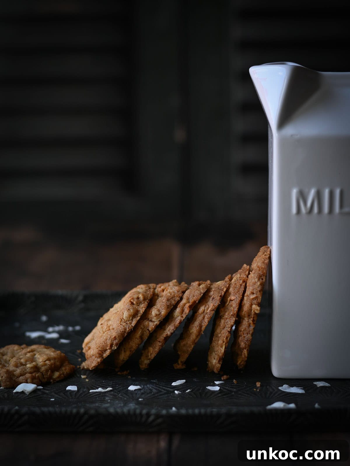 Coconut cookies leaned up against a white milk carton.