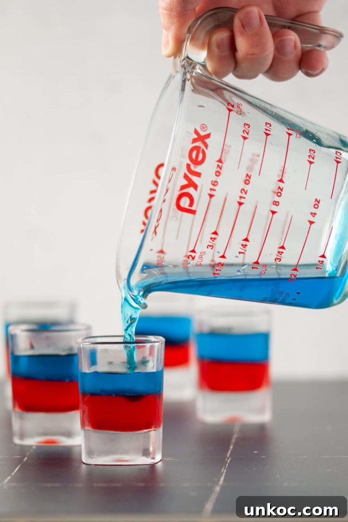 5 Ingredient Red White and Blue Jello Shots 6 Layering Blue Jello on Top Of Red Jello in a Shot Glass