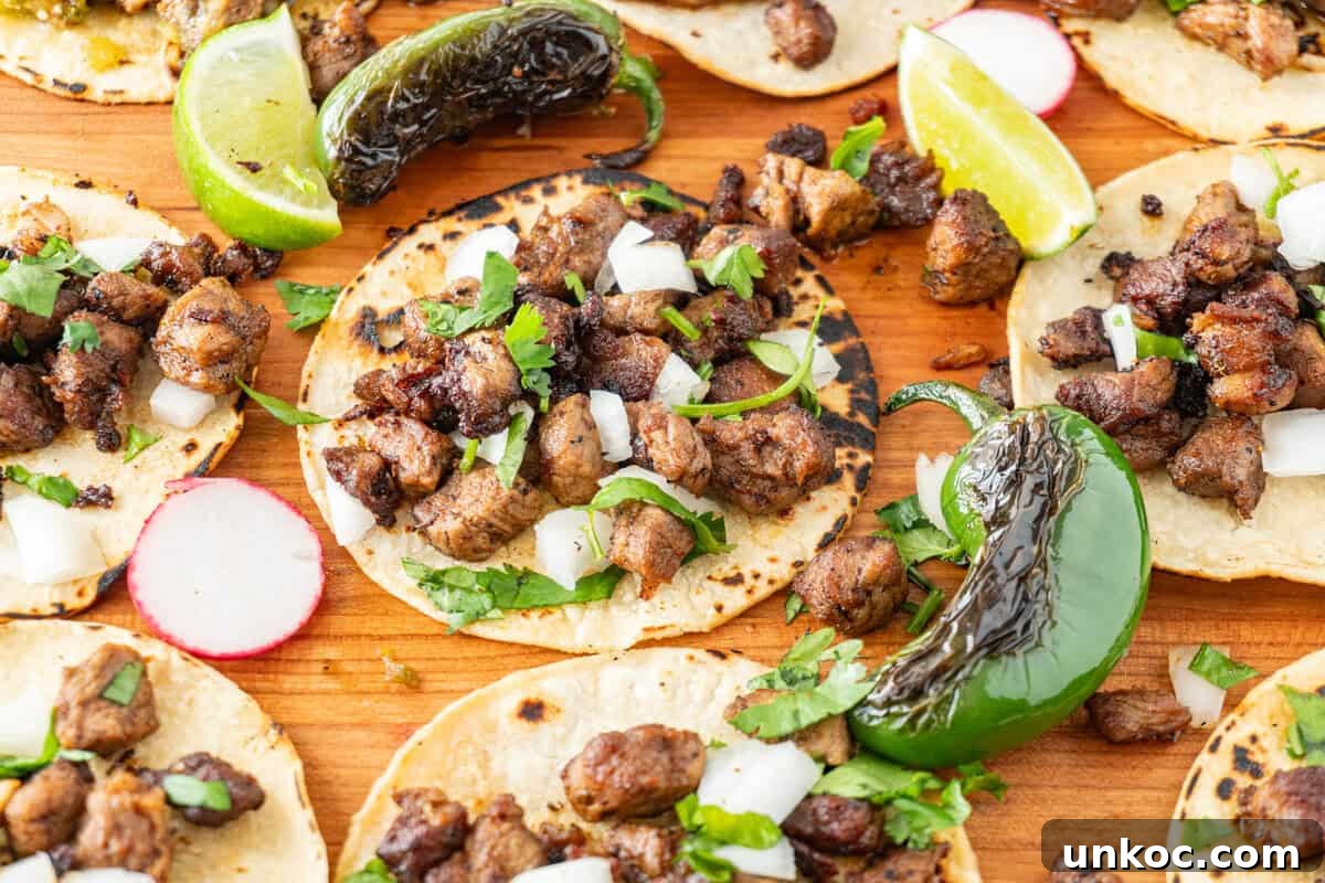 Taco sprinkled with onion and cilantro on a cutting board surrounded by blackened jalapeno, radish slices, and lime wedges.
