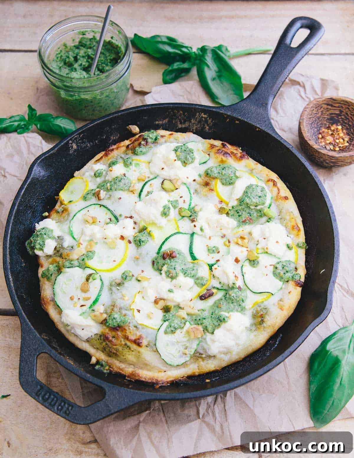 This skillet zucchini pesto pizza has a crispy yet chewy crust. With layers of tangy basil pesto, mozzarella, zucchini and ricotta it's perfect for summer!