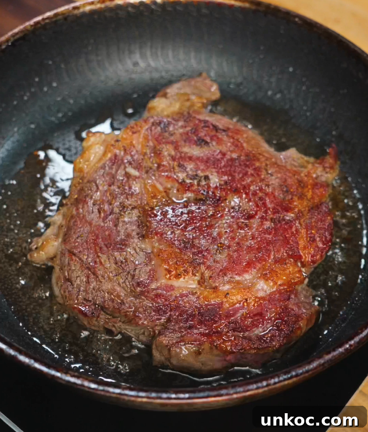 Japanese Steak Donburi Rice Bowl Recipe 6 Ribeye steak sizzling in a hot pan with a deep golden crust forming for steak rice bowl.