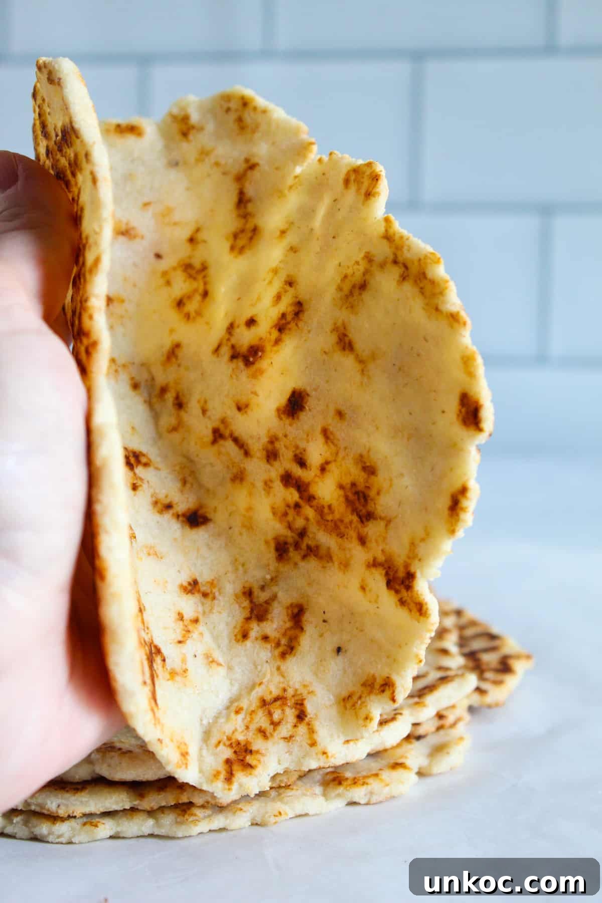 Soft Keto Almond Flour Tortillas That Fold Without Cracking 17 Fluffy Gluten Free Tortilla being folded in a hand.
