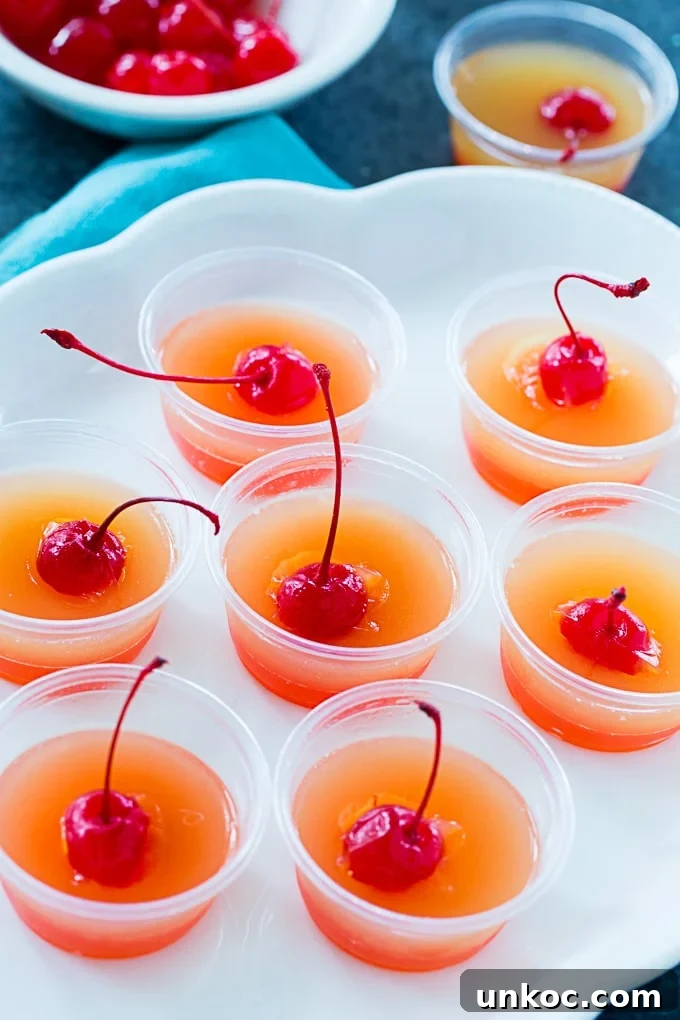 Pineapple Upside-Down Cake Jello Shots for Summer Parties 4 Jello shots on a plate.