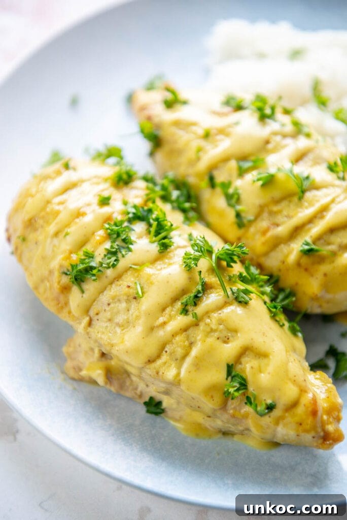 Slow Cooker Honey Mustard Chicken Recipe 9 two honey mustard chicken breasts on a plate