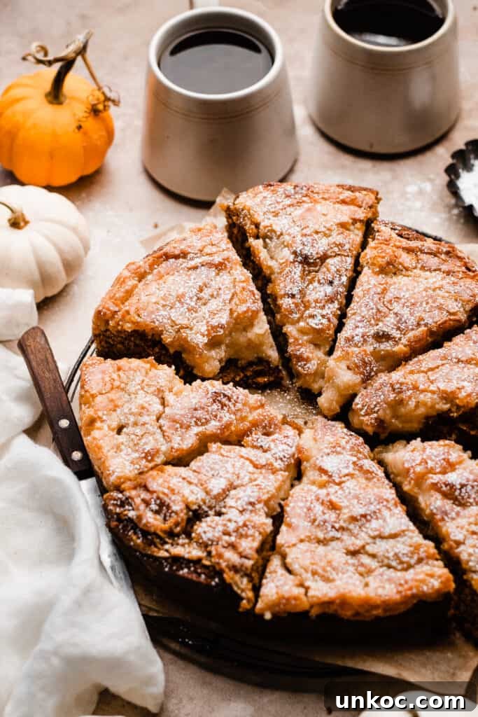 Pumpkin Gooey Butter Cake Recipe 3 Pumpkin gooey butter cake slices on a wire rack, dusted with powdered sugar.