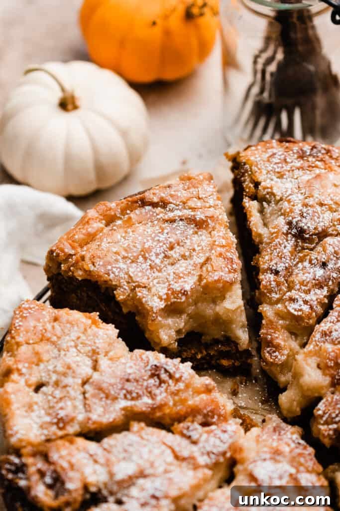 Pumpkin Gooey Butter Cake Recipe 4 A close-up on a slice of pumpkin gooey butter cake with a bite missing.