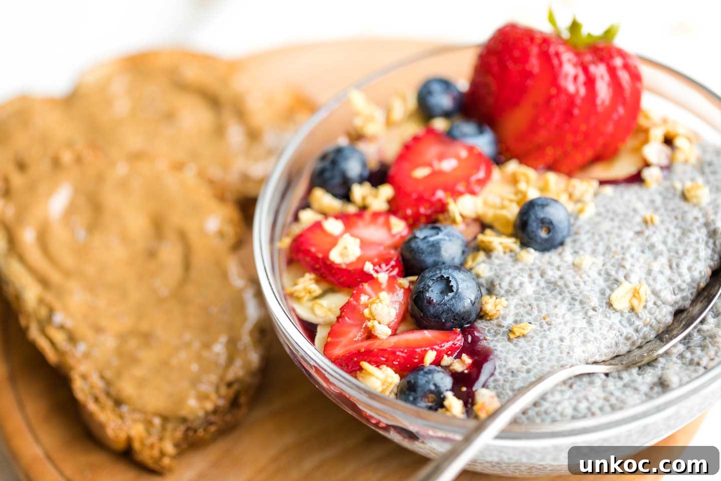 First Watch Copycat Recipe AM Superfoods Bowl Chia Pudding serving bowl of chia pudding with fruit, surrounded by toast topped with almond butter
