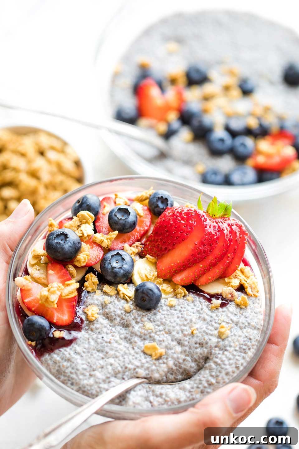 How to Make First Watch Chia Pudding with Coconut Milk Recipe hands holding bowl of breakfast chia pudding, with serving bowl in background