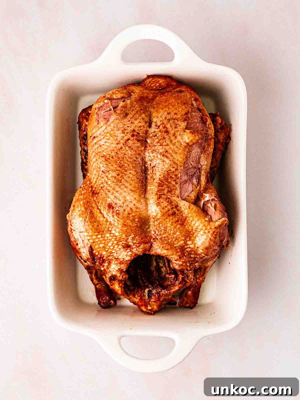 A slow cooked duck in a roasting dish.