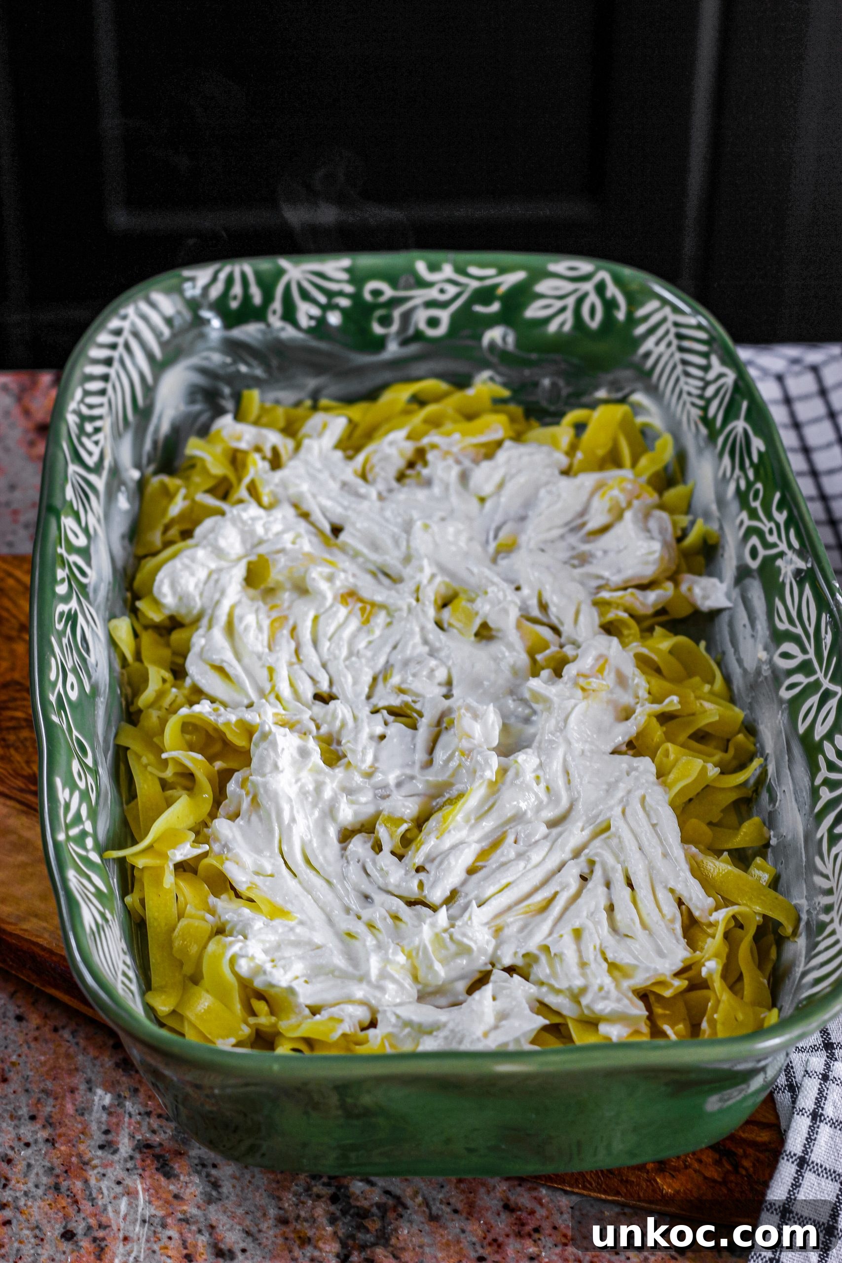 Poor Mans Husband Casserole with Ground Beef 12 Layering noodles and creamy filling in baking dish