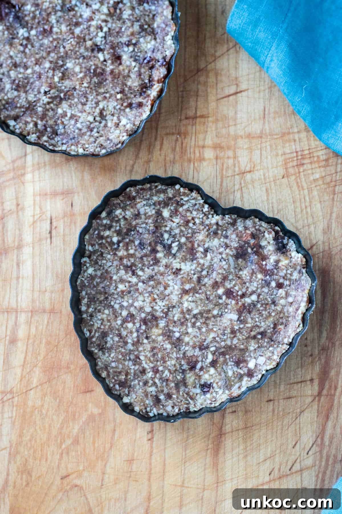 Vegan Raw Raspberry Cheesecake Recipe 4 Crust pressed into heart shaped tart pans.