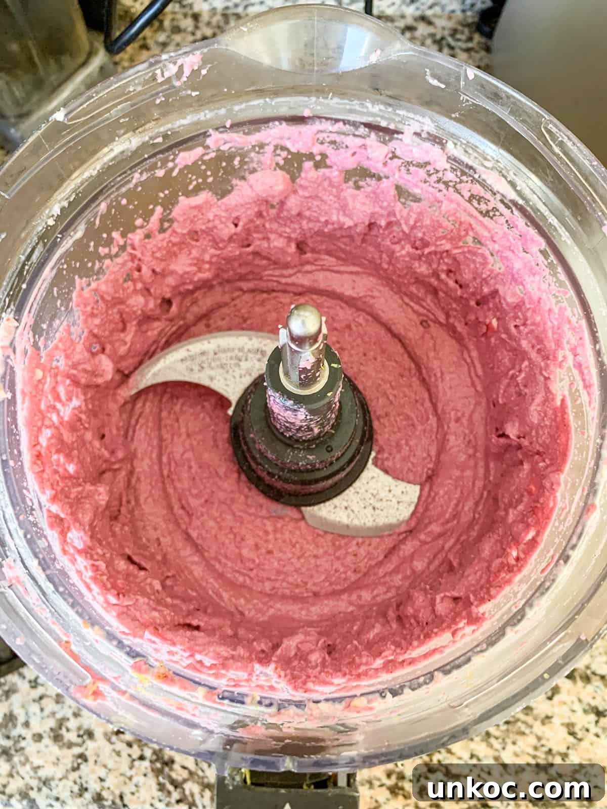 Vegan Raw Raspberry Cheesecake Recipe 5 Creamy raspberry filling in a food processor.