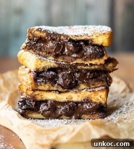 3 French toast sandwiches stacked on each other with chocolate spilling out