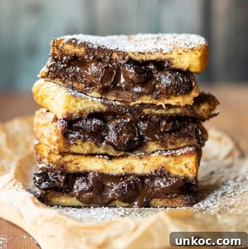 3 French toast sandwiches stacked on each other with chocolate spilling out