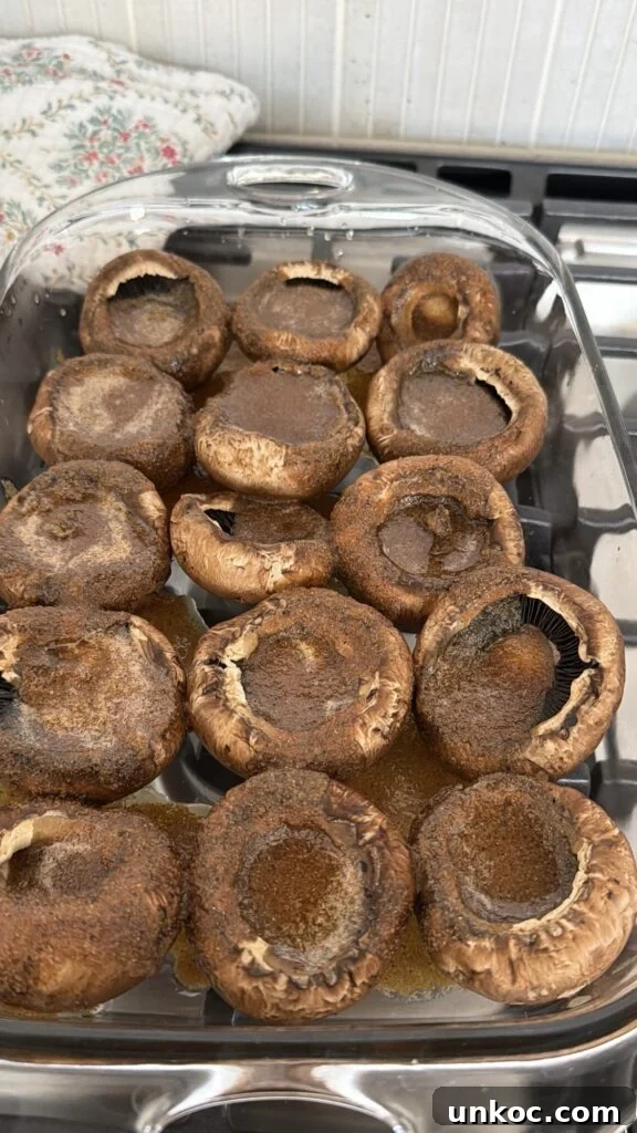 The mushroom caps topped with marinade before baking
