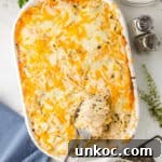 Chicken tetrazzini in white baking dish with spoon.