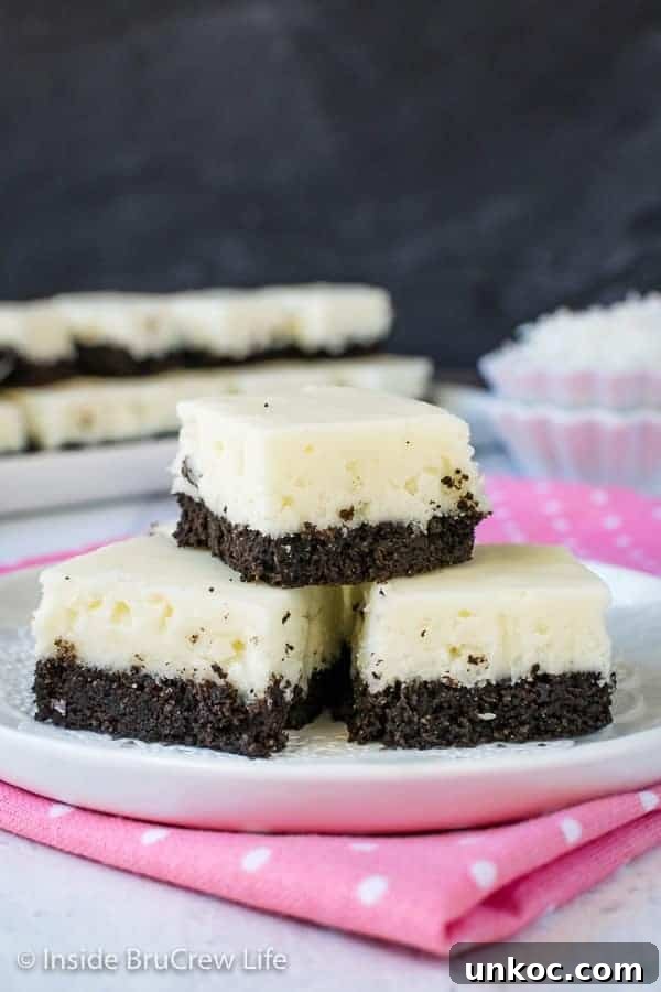 Coconut Oreo Fudge - this easy fudge has a great coconut flavor and a sweet chocolate cookie crust. Make this no bake recipe for spring or summer. #fudge #coconut #Oreocookies #nobake #spring #Easter #dessert #coconutcream 3 pieces of white coconut fudge with an oreo cookie base on a white plate.
