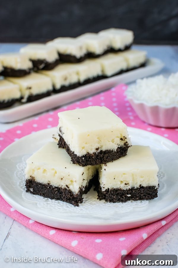 Coconut Oreo Fudge - this easy fudge has three times the coconut and a cookie crust. It is the perfect spring or summer dessert. #fudge #coconut #Oreocookies #nobake #spring #Easter #dessert #coconutcream 3 pieces of white coconut fudge with an oreo cookie base on a white plate.