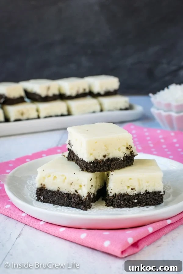 Coconut Oreo Fudge - a chocolate cookie crust makes this amazing coconut fudge taste so good. Great recipe to make for spring or summer parties! #fudge #coconut #Oreocookies #nobake #spring #Easter #dessert #coconutcream 3 pieces of white coconut fudge with an oreo cookie base on a white plate.