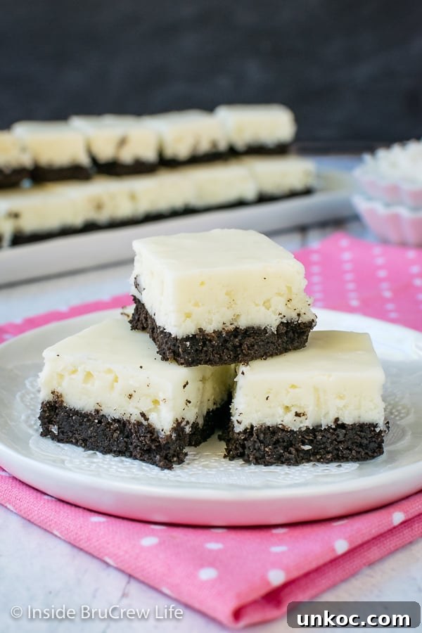 Coconut Oreo Fudge - the chocolate cookie crust adds so much flavor and fun to this easy coconut fudge recipe. #fudge #coconut #Oreocookies #nobake #spring #Easter #dessert #coconutcream 3 pieces of white coconut fudge with an oreo cookie base on a white plate.