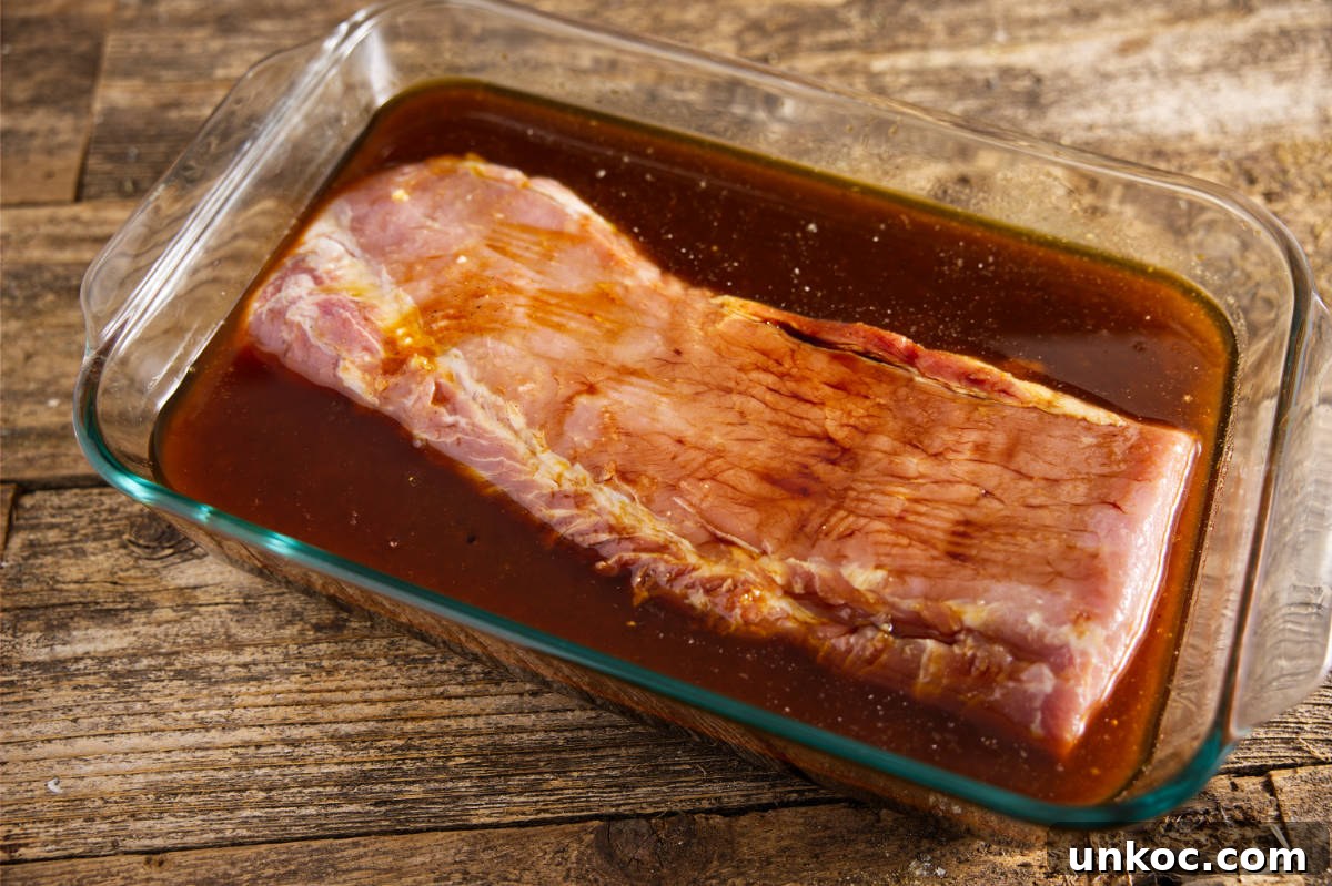 Pork loin soaking in marinade in large Pyrex.