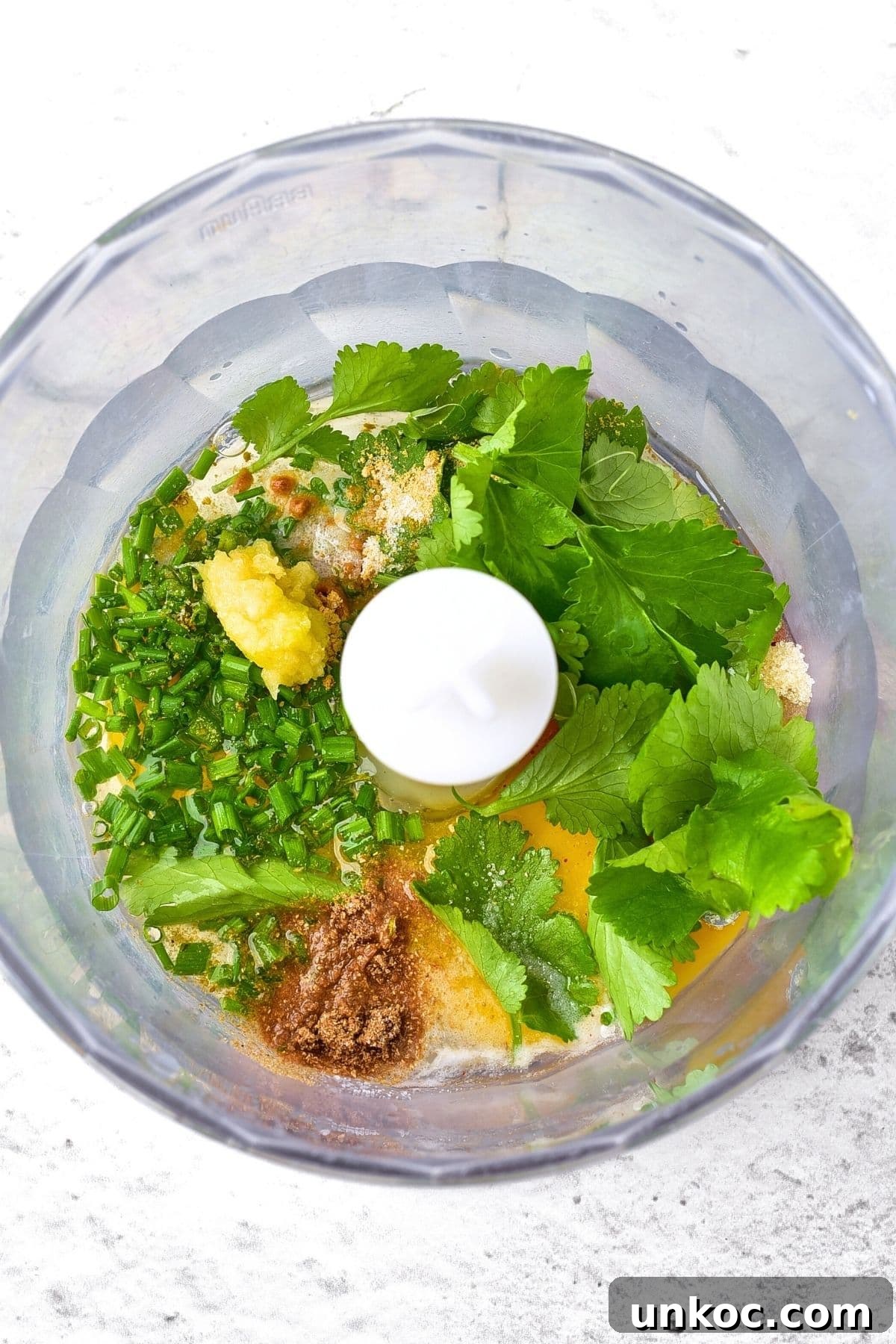 Fresh herbs, grated garlic, spices, egg and oil in food processor.