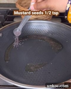 Jaffna Eggplant Chickpea Curry Sri Lankan Brinjal Recipe 13 Adding mustard seeds to a hot pan for Sri Lankan brinjal curry.