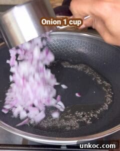 Jaffna Eggplant Chickpea Curry Sri Lankan Brinjal Recipe 15 Onion 1 cup being added to a frying pan.