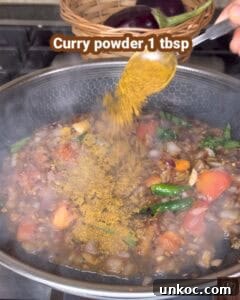 Jaffna Eggplant Chickpea Curry Sri Lankan Brinjal Recipe 25 Cooking Jaffna brinjal curry with spices and vegetables in a pan.