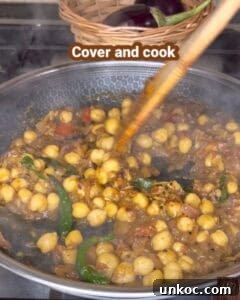 Jaffna Eggplant Chickpea Curry Sri Lankan Brinjal Recipe 31 Jaffna brinjal and chickpea curry cooking in a pot with green chilies.