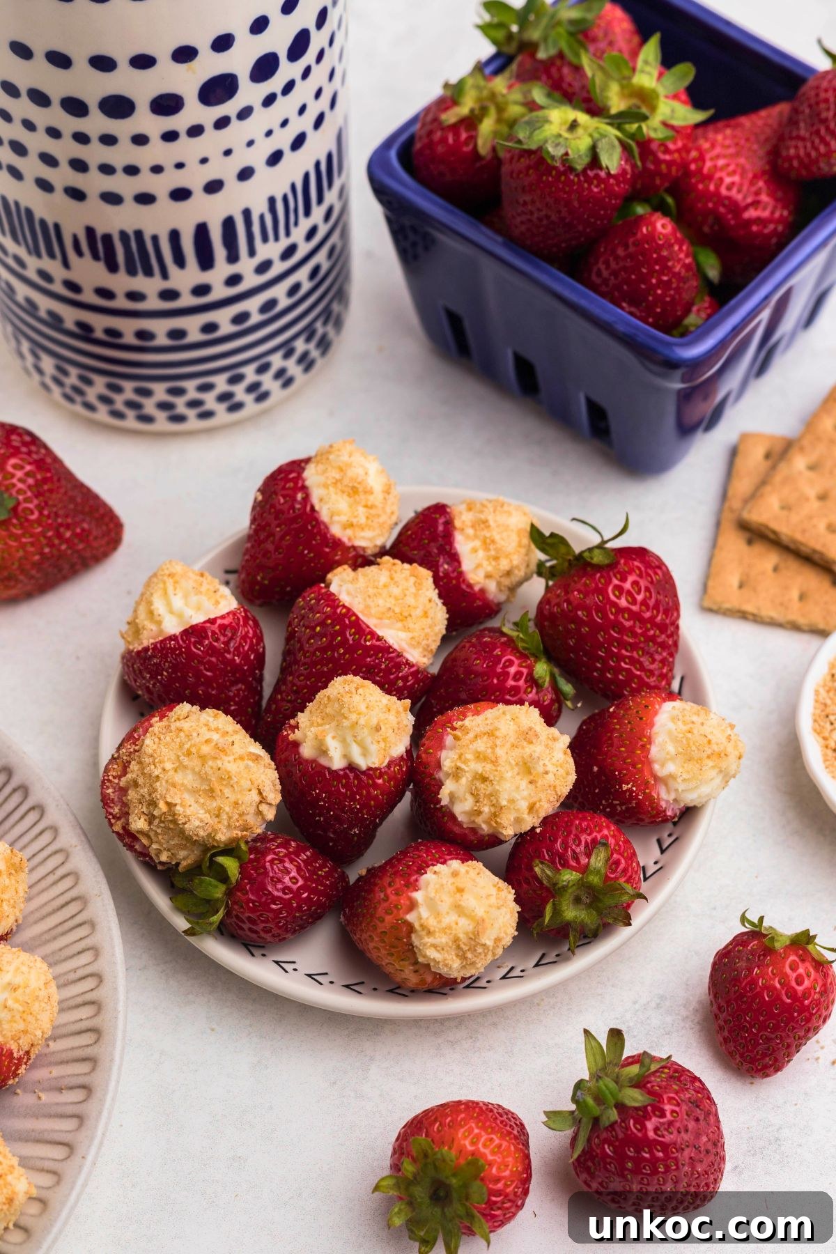 Cheesecake Stuffed Strawberries Recipe 2 Cheesecake stuffed strawberries on a marble table.