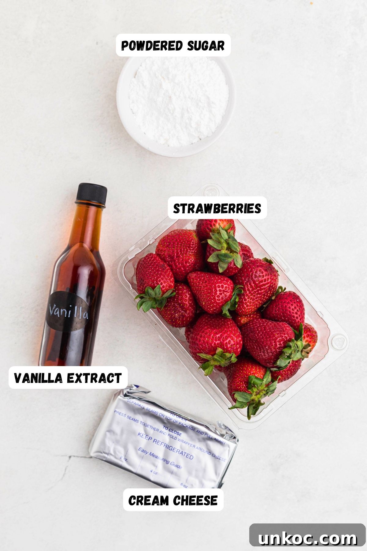 Cheesecake Stuffed Strawberries Recipe 3 Strawberries, vanilla, cream cheese, and powdered sugar measured on a marble table.