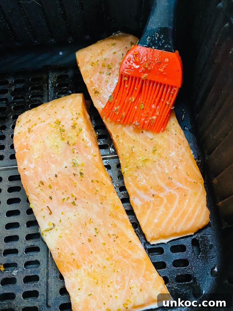 Crispy Air Fryer Lemon Salmon with Roasted Broccoli 5 brushing salmon with the seasoned lemon butter