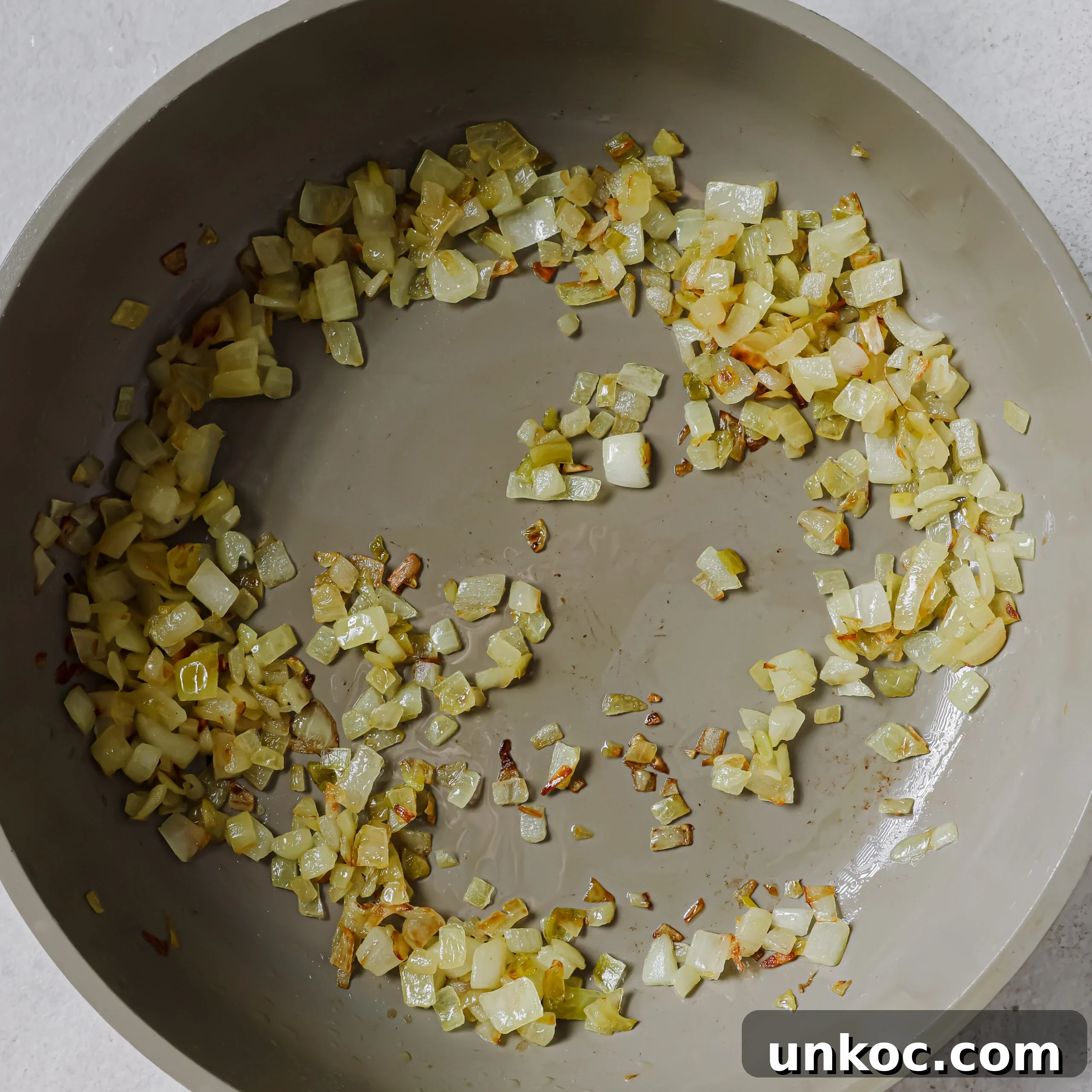 Creamy Cauliflower Au Gratin with Golden Cheese Crust 5 Onions cooking in a skillet.