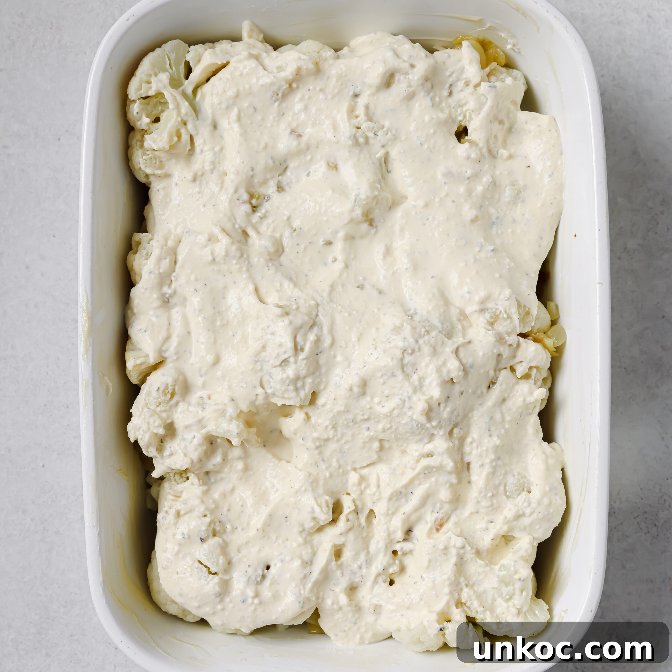 Creamy Cauliflower Au Gratin with Golden Cheese Crust 9 Cauliflower with creamy cheese sauce in a white casserole dish.