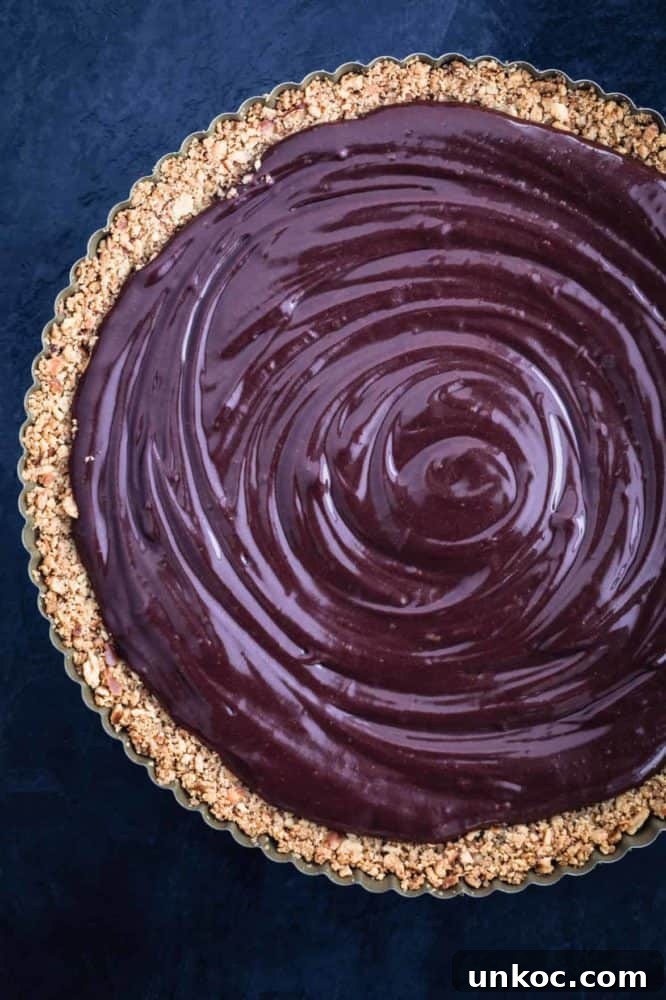 Chocolate Tahini Tart Recipe with Silky Ganache 12 Chocolate ganache filling is poured into pretzel crust.