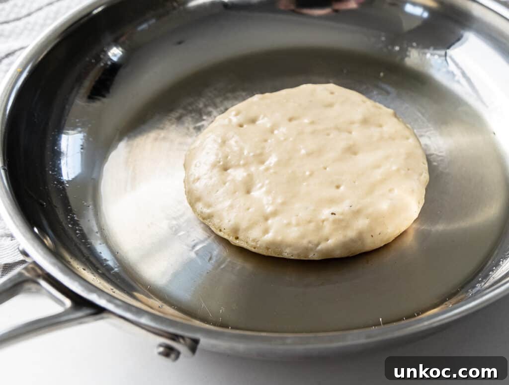 Fluffy Oat Milk Pancakes Recipe 3 Bubbly pancake ready to be flipped in the skillet