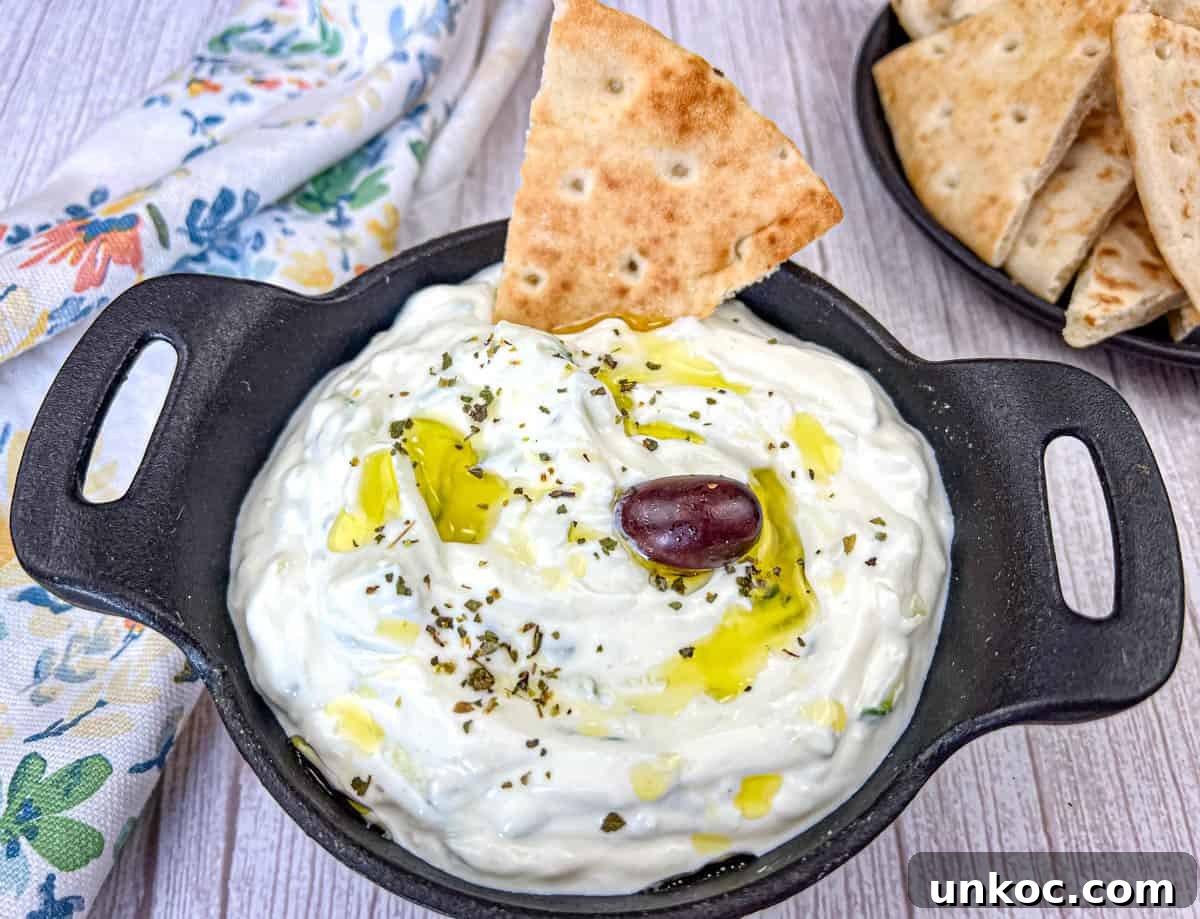 Tzatziki Sauce with pita dipped in a black bowl.