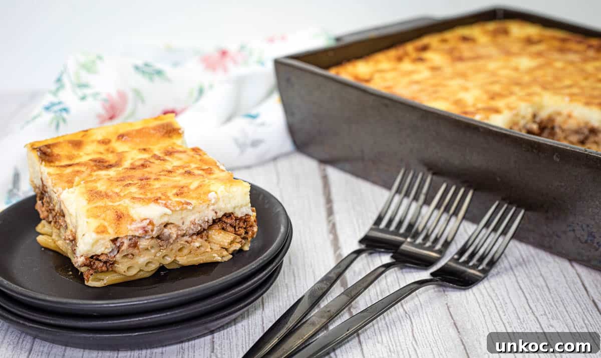 A square piece of pastitsio dish served on a stack of black plates.