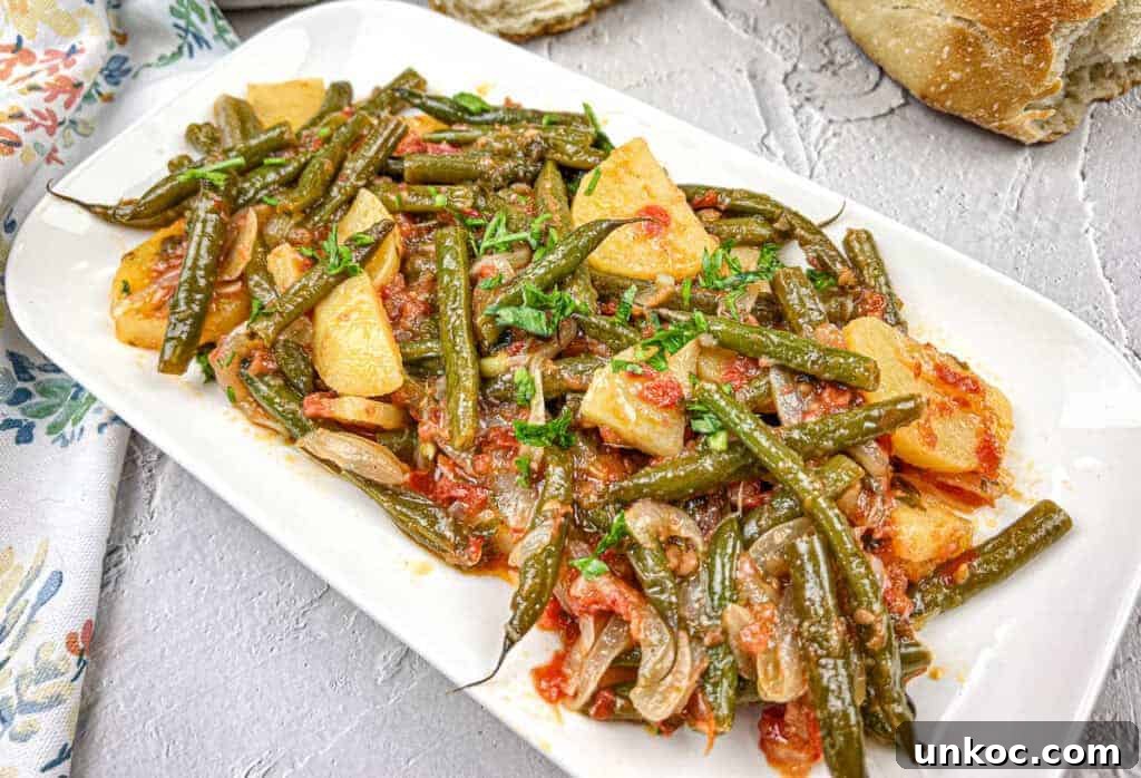 Greek Green Beans served on a white rectangular plate.