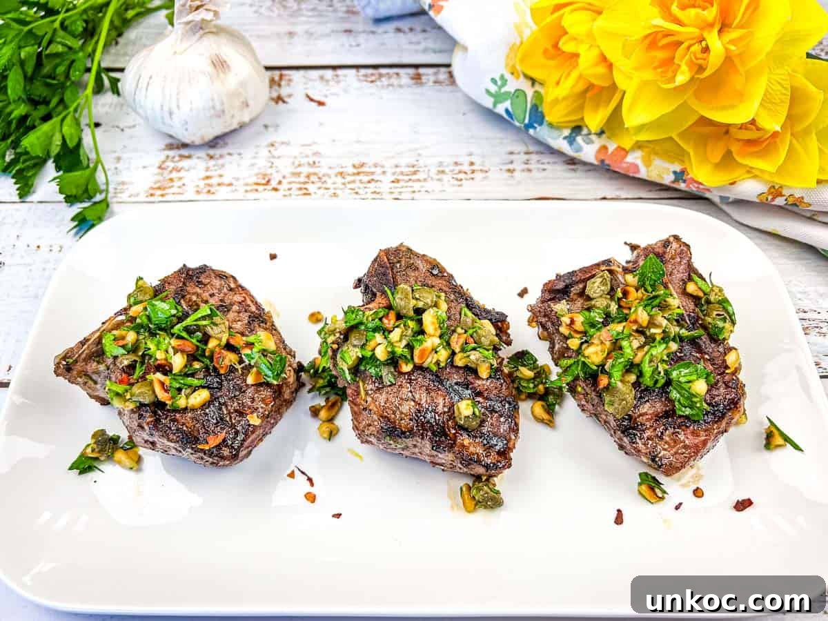 Three Ninja Woodfire Grill Mediterranean Lamb Chops topped with gremolata on a white plate.