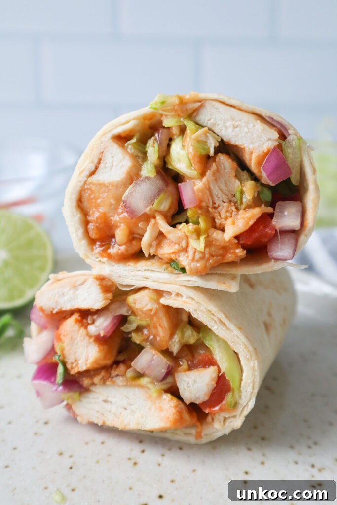 30 Minute Sriracha Chicken Wraps 2 sriracha chicken wraps sliced and stacked on top of each other.