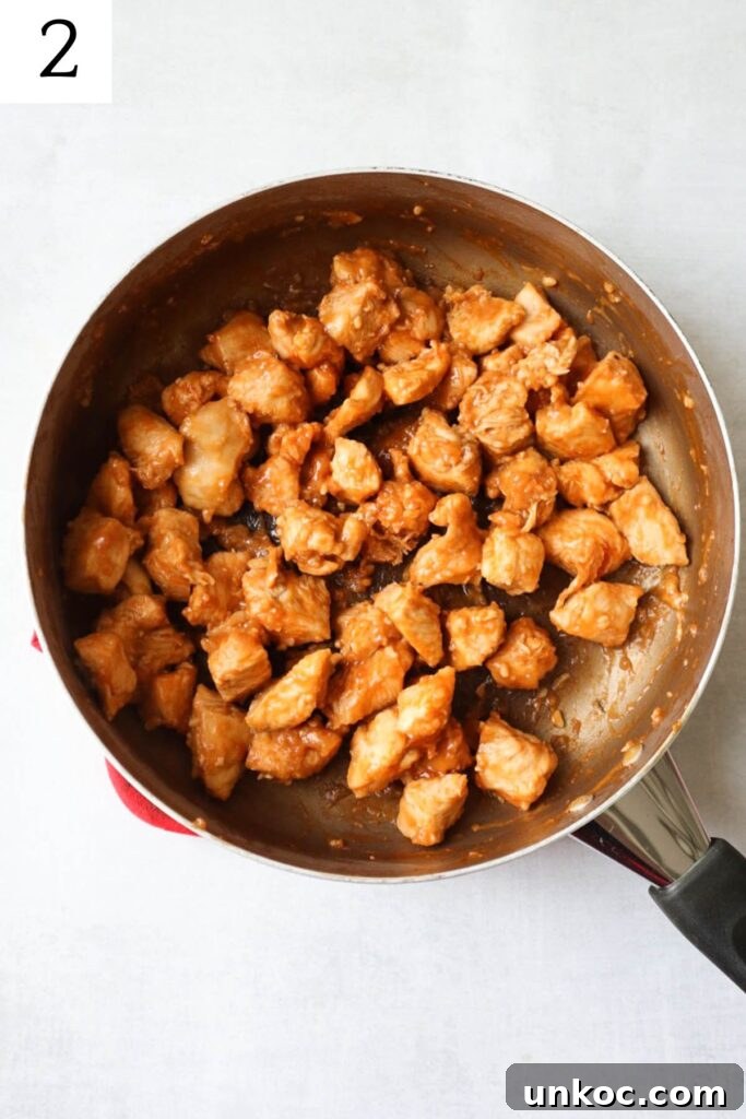 30 Minute Sriracha Chicken Wraps 5 skillet with chicken cooked in a honey sriracha sauce.