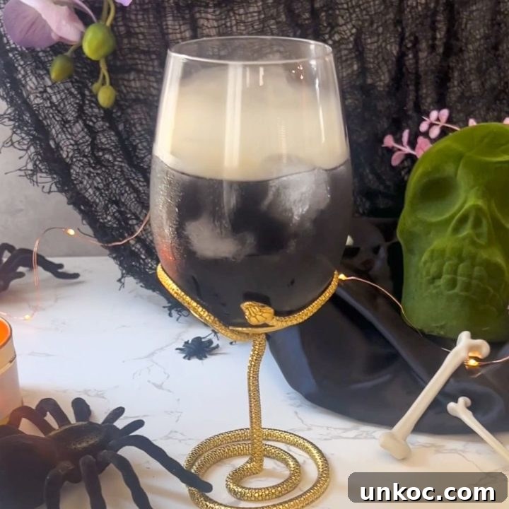 a smoked cocktail served in a snake glass for a Halloween party