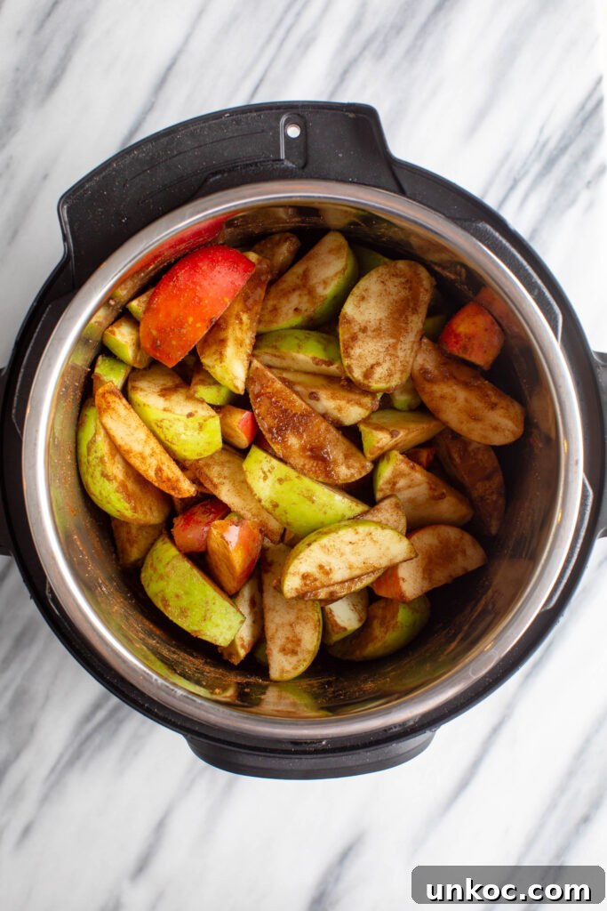 Instant Pot Apple Butter Recipe No Peeling Required 6 sliced green and red apples mixed with spices in an instapot